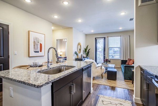 Modern kitchen with stainless steel appliances and granite countertops in West End Apartments