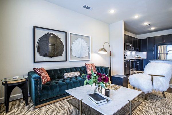 Living room with contemporary decor and large windows at West End Apartments