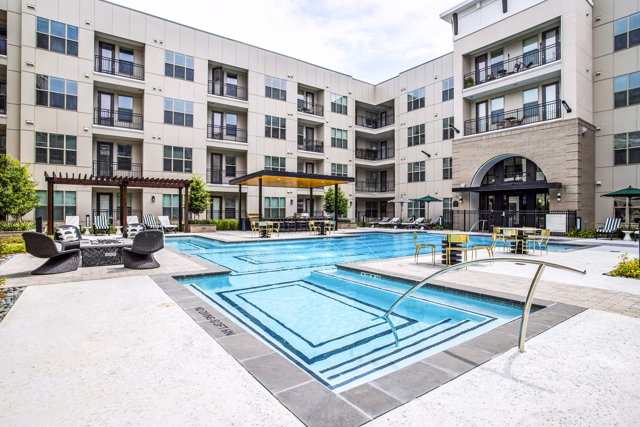 Resort-style pool at West End Apartments with comfortable lounge areas and lush landscaping, perfect for relaxation and leisure activities