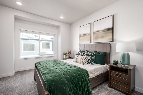 Bedroom featuring modern decor and plush bedding in The Orchard Townhomes