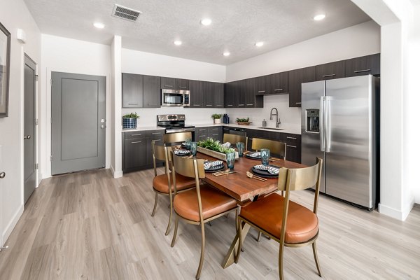 Dining area with modern furnishings and a stylish chandelier in The Orchard Townhomes apartments