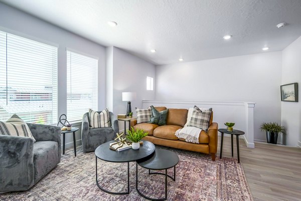 Upstairs living room featuring cozy seating and ample natural light at The Orchard Townhomes