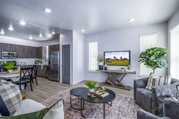 Modern living room with cozy furnishings and large windows in The Orchard Townhomes