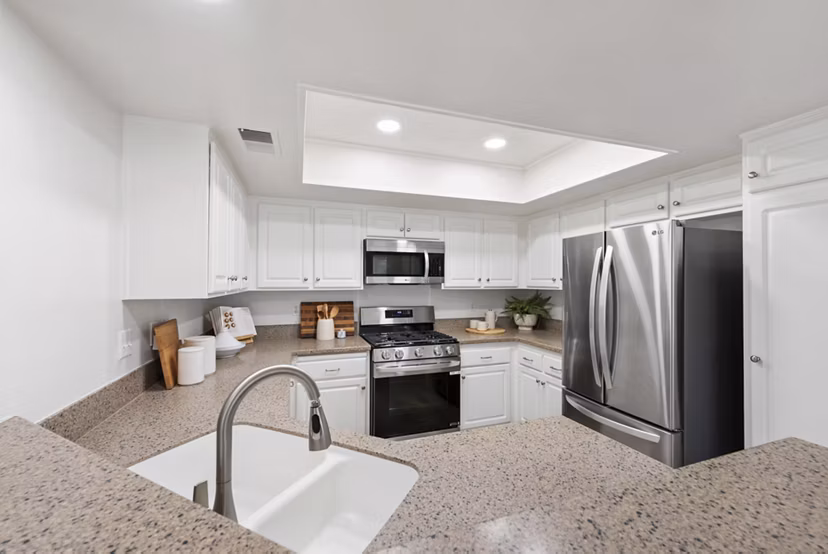 Spacious kitchen with island and stainless steel appliances at St Moritz Apartments