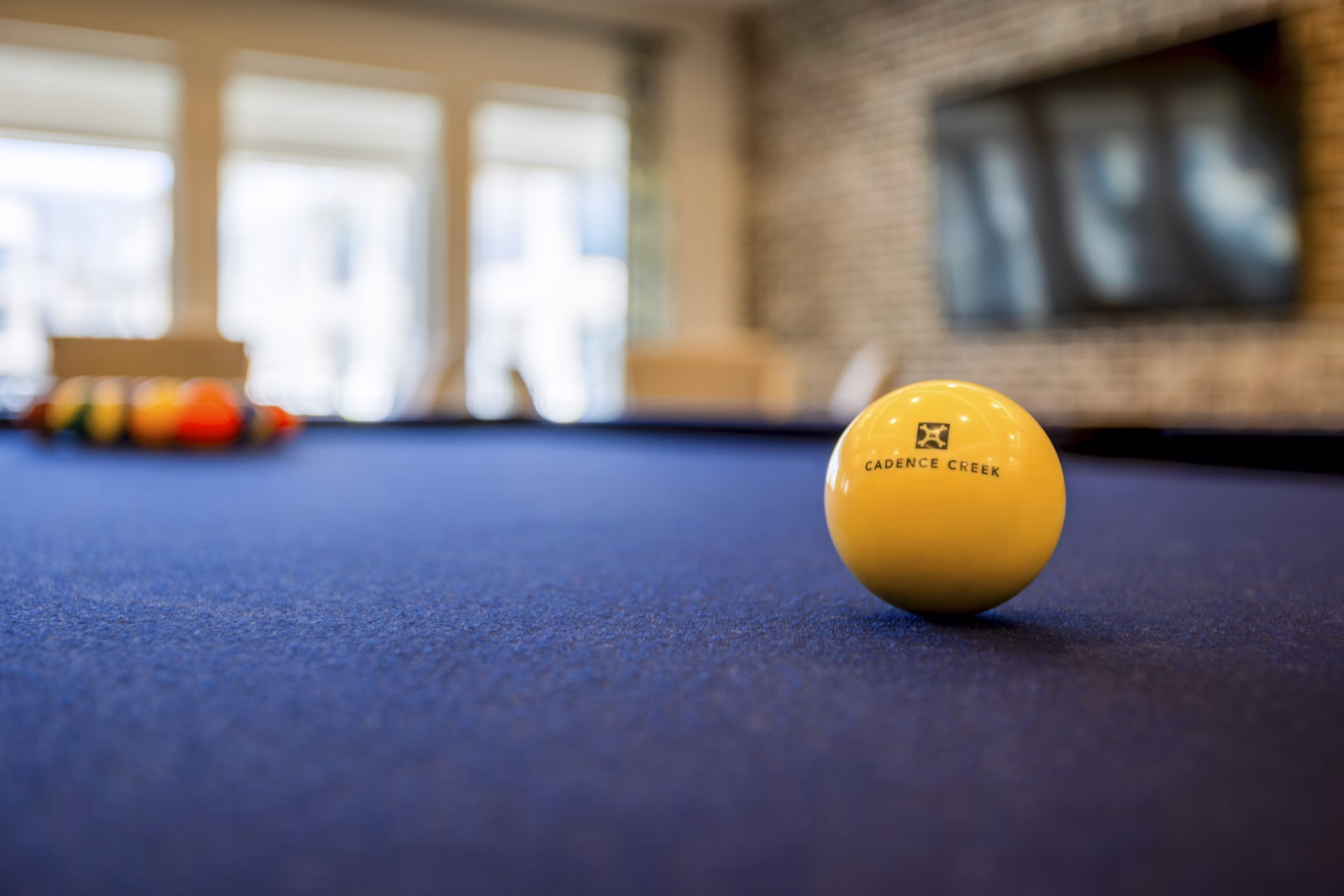 Clubhouse game room with pool table and seating at Cadence Creek at Towne Lake Apartments, offering a fun space for socializing and recreation