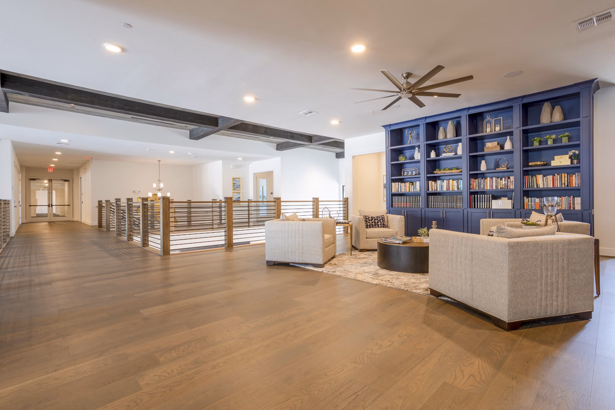 Clubhouse library with cozy seating and shelves of books at Cadence Creek at Towne Lake Apartments