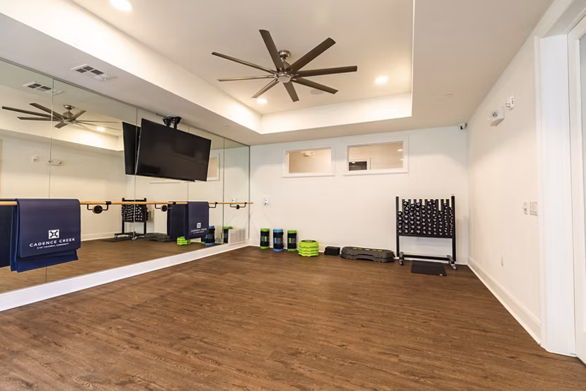 Yoga studio with natural light and sleek flooring at Cadence Creek at Towne Lake Apartments