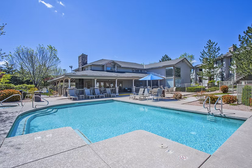 Resort-style pool with lounge chairs at Legacy at Prescott Lakes Apartments