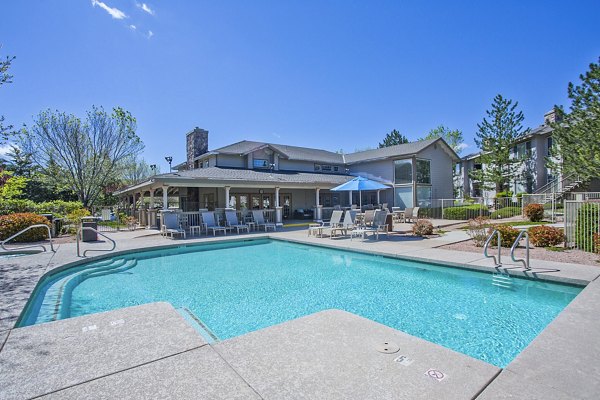 Resort-style pool with lounge chairs at Legacy at Prescott Lakes Apartments