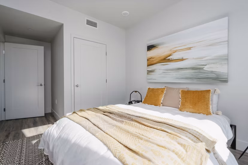 Cozy bedroom with modern decor at Assembly Apartments, featuring stylish furnishings and ample natural light