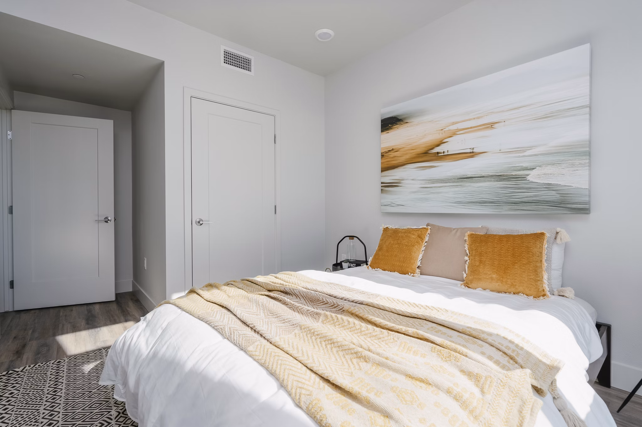 Cozy bedroom with modern decor at Assembly Apartments, featuring stylish furnishings and ample natural light