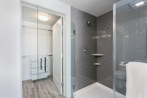 Modern bathroom featuring sleek fixtures and ample storage space in Assembly Apartments