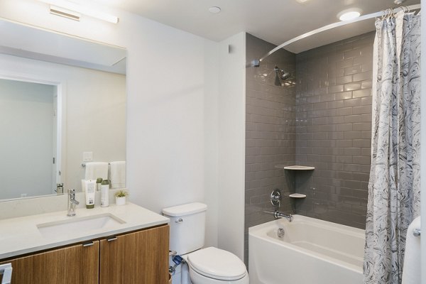 Contemporary bathroom featuring sleek fixtures and marble countertop at Assembly Apartments