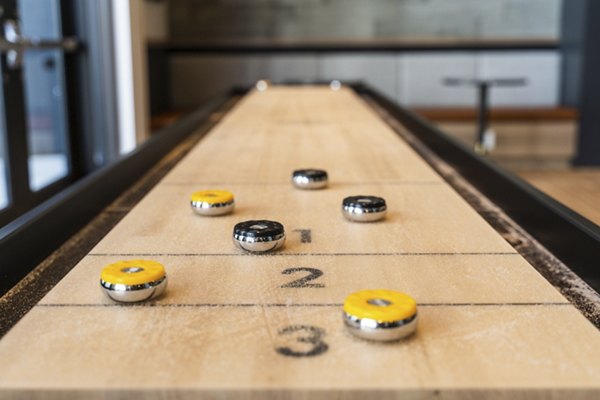 Game room with modern decor featuring pool table and lounge seating at Assembly Apartments