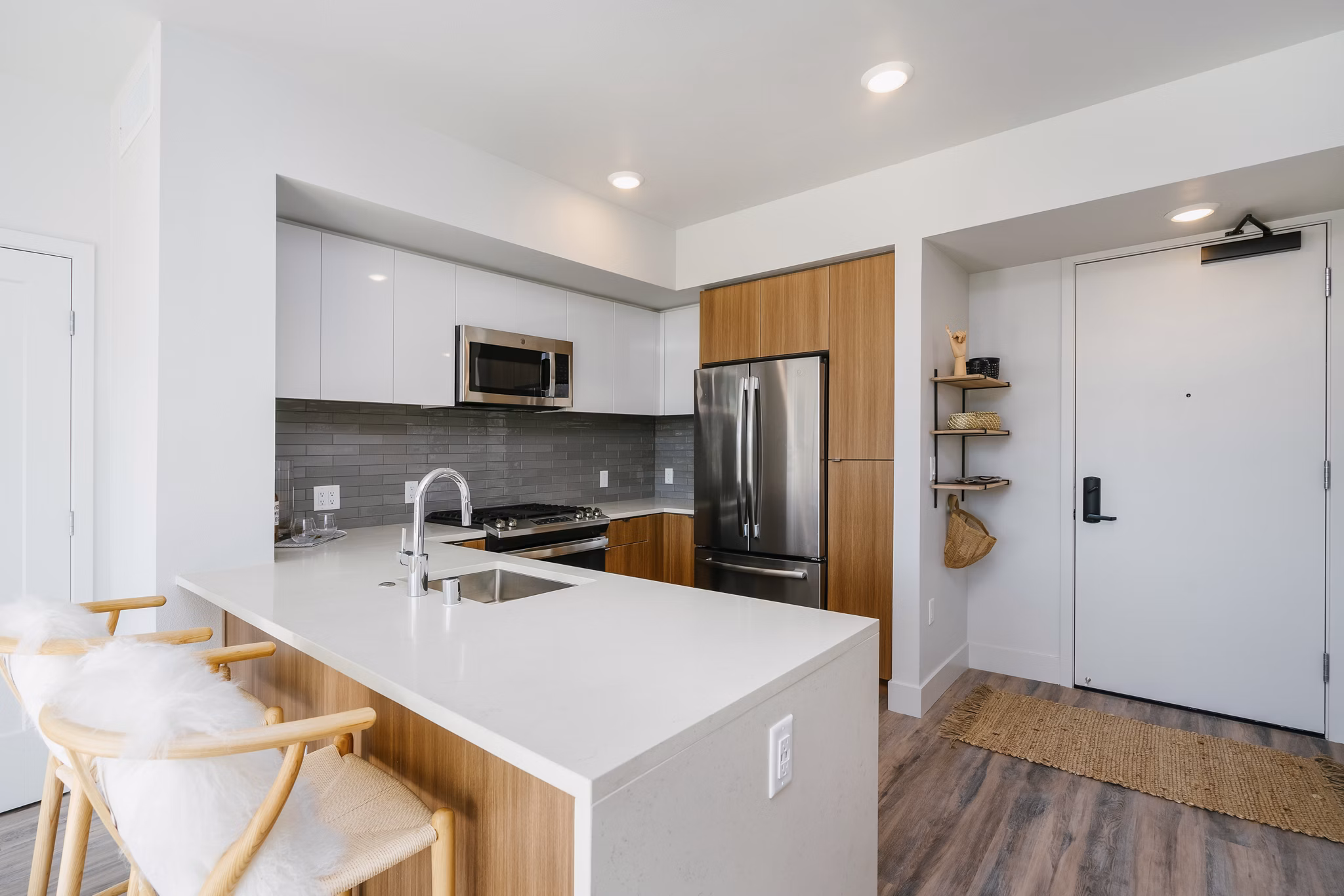 Modern kitchen featuring stainless steel appliances and granite countertops at Assembly Apartments