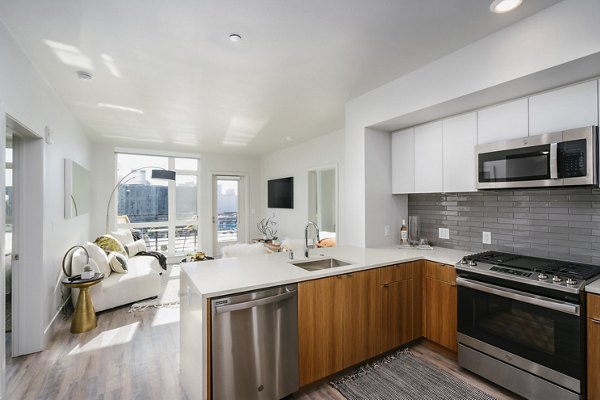Kitchen with sleek countertops and modern appliances at Assembly Apartments, luxury living in the heart of vibrant urban community