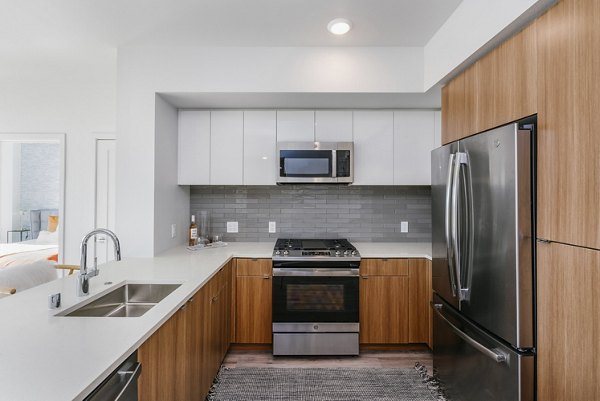 Spacious kitchen featuring modern appliances in Assembly Apartments luxury residence