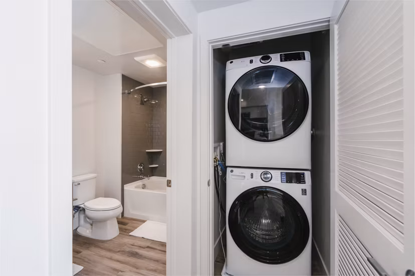 Modern laundry room with energy-efficient washers and dryers at Assembly Apartments
