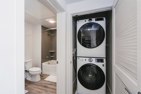 Modern laundry room with energy-efficient washers and dryers at Assembly Apartments