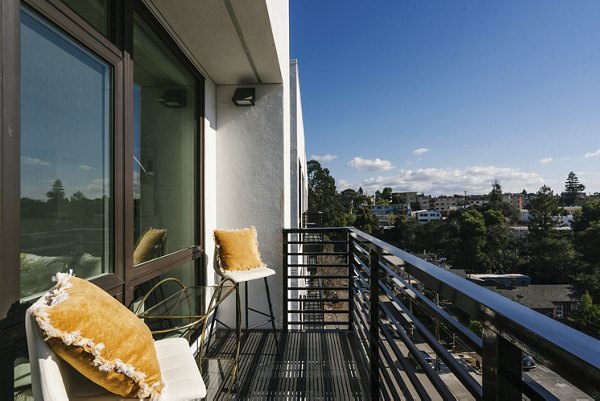 Cozy outdoor patio at Assembly Apartments with modern seating and lush plants, perfect for relaxation in a serene environment