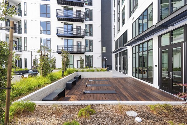 Outdoor sport court at Assembly Apartments featuring basketball hoops and tennis nets