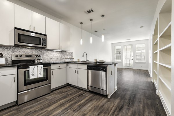 Modern kitchen with sleek countertops and stainless steel appliances in Crescent Apartments