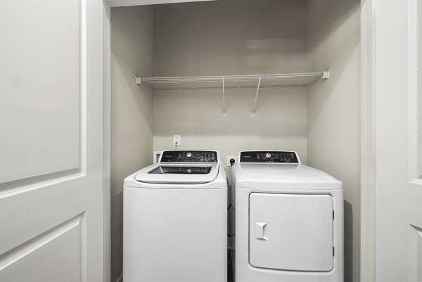 Laundry room featuring modern appliances at Elements Barclay Station luxury apartments