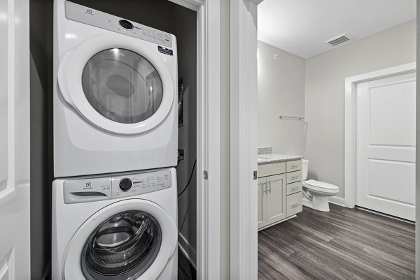 Modern laundry room with high-efficiency washers and dryers at Elements Barclay Station luxury apartments