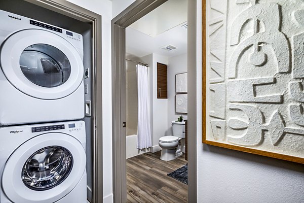 Bath and laundry room with modern appliances at Citron Apartments
