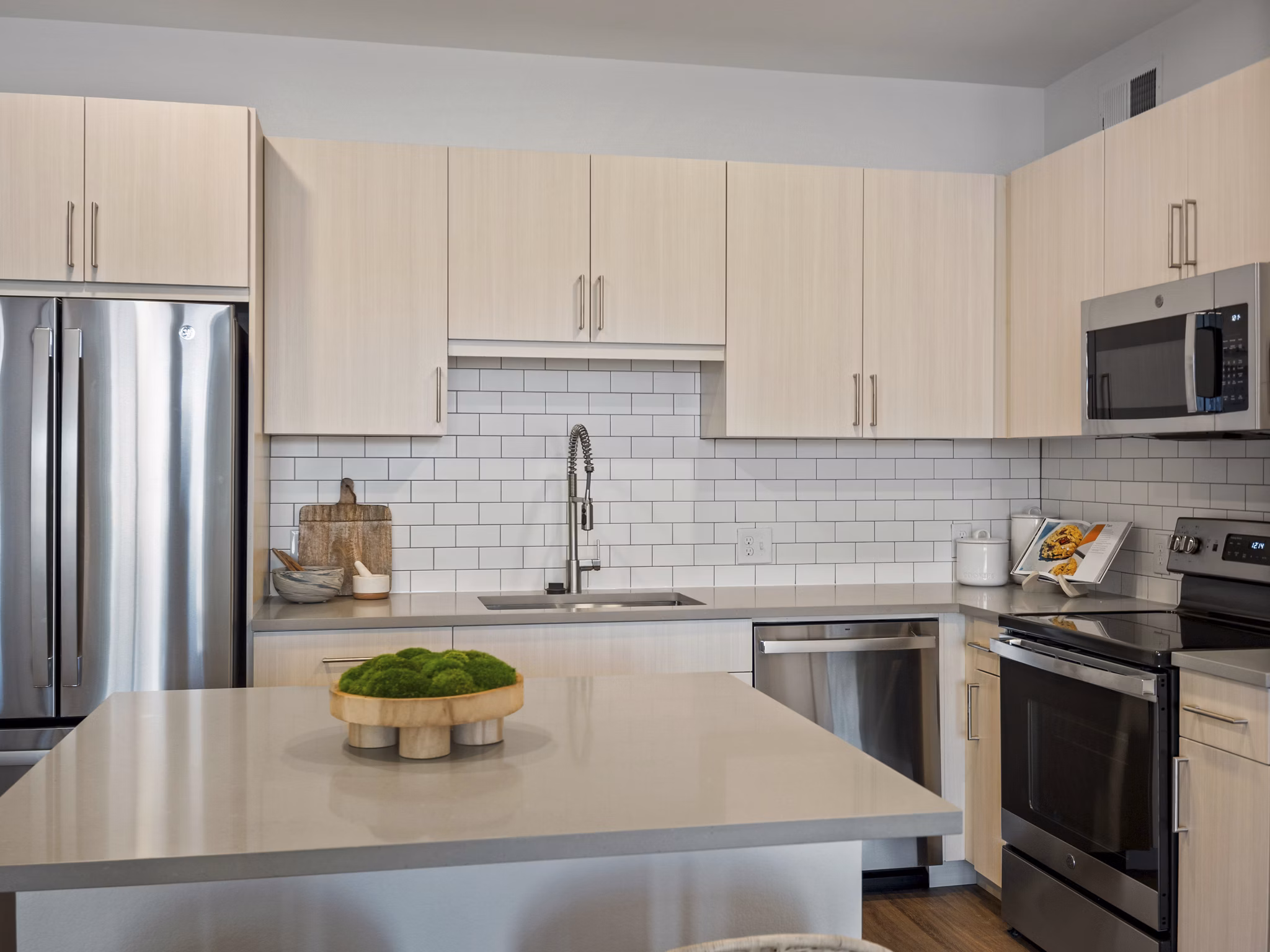 Modern kitchen with stainless steel appliances in Fieldhouse Apartments
