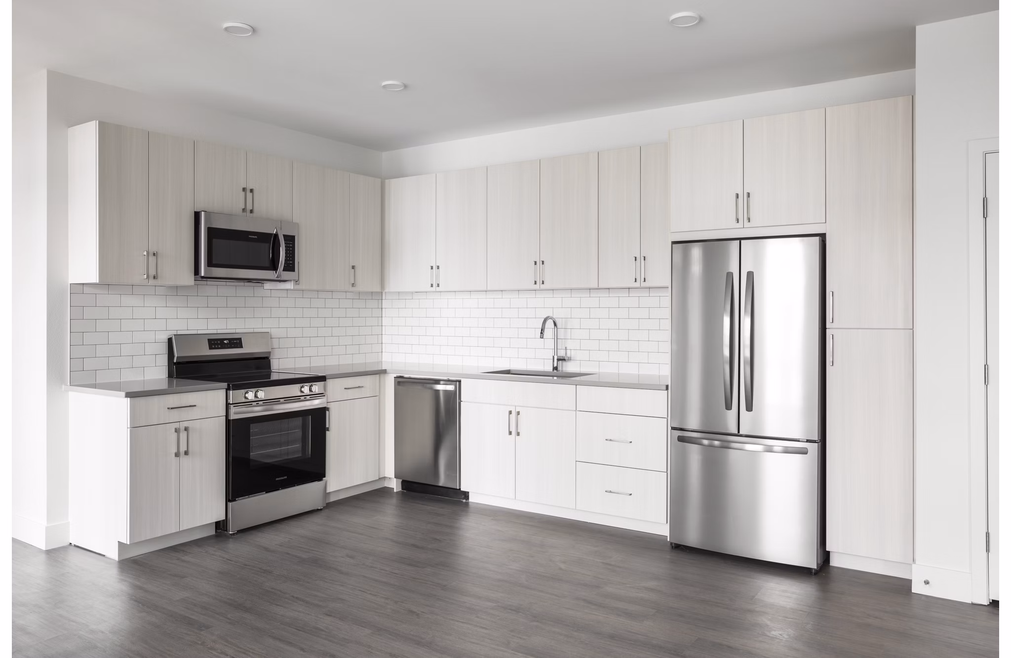 Modern kitchen with stainless steel appliances at Origin Apartments featuring sleek cabinetry and spacious countertops