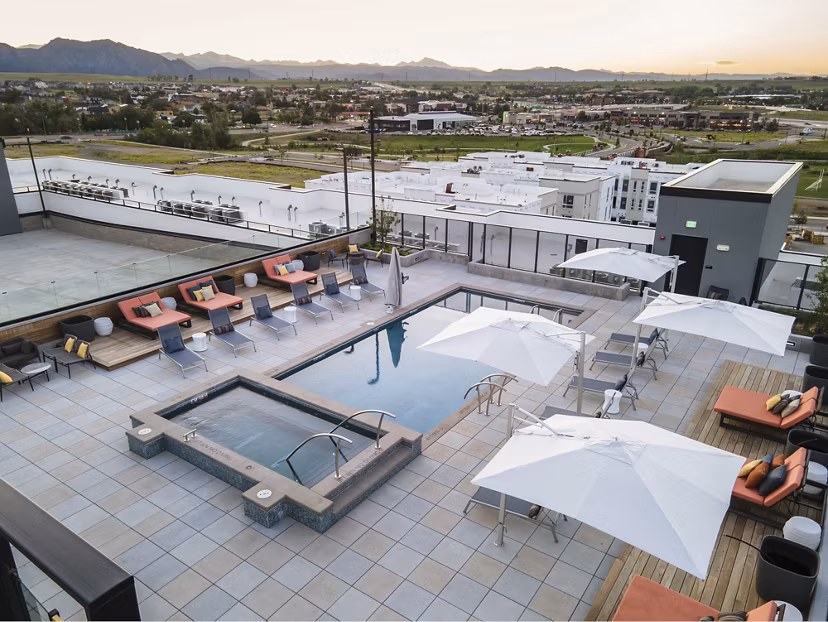 Infinity pool with lounge chairs at Origin Apartments