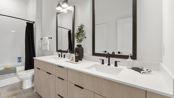 Sleek bathroom featuring marble countertops and modern fixtures at Infield Apartments