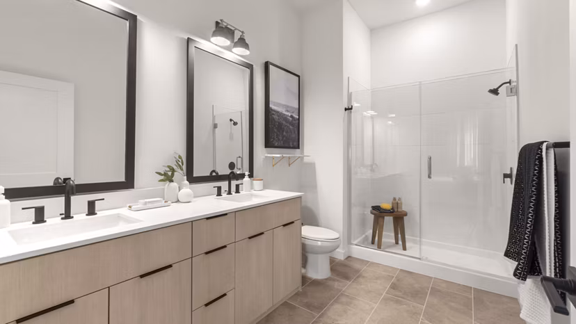 Modern bathroom featuring sleek fixtures and large vanity mirror at Infield Apartments