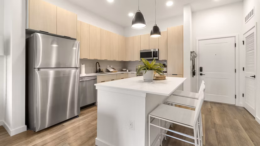 Modern kitchen with stainless steel appliances at Infield Apartments, showcasing sleek countertops and ample storage