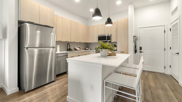 Modern kitchen with stainless steel appliances at Infield Apartments, showcasing sleek countertops and ample storage