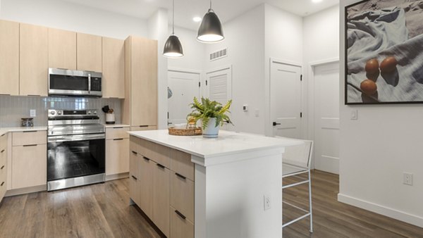 Modern kitchen with sleek appliances and granite countertops in Infield Apartments