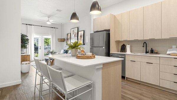 Modern kitchen with stainless steel appliances and granite countertops at Infield Apartments