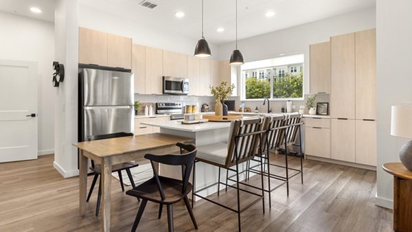 Modern kitchen featuring stainless steel appliances and granite countertops at Infield Apartments