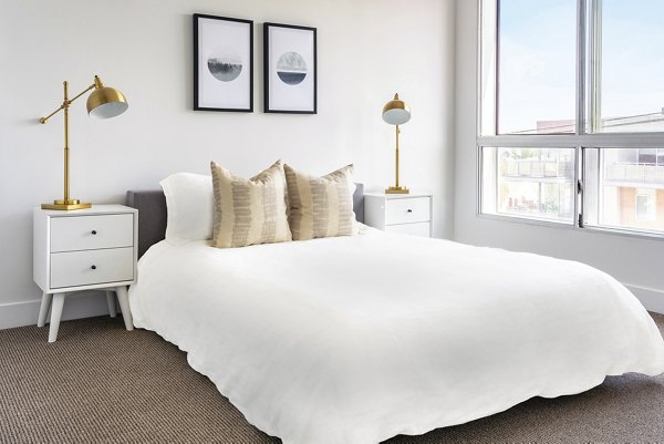 The LC Apartments: Modern bedroom with sleek furnishings and natural light ideal for luxury living