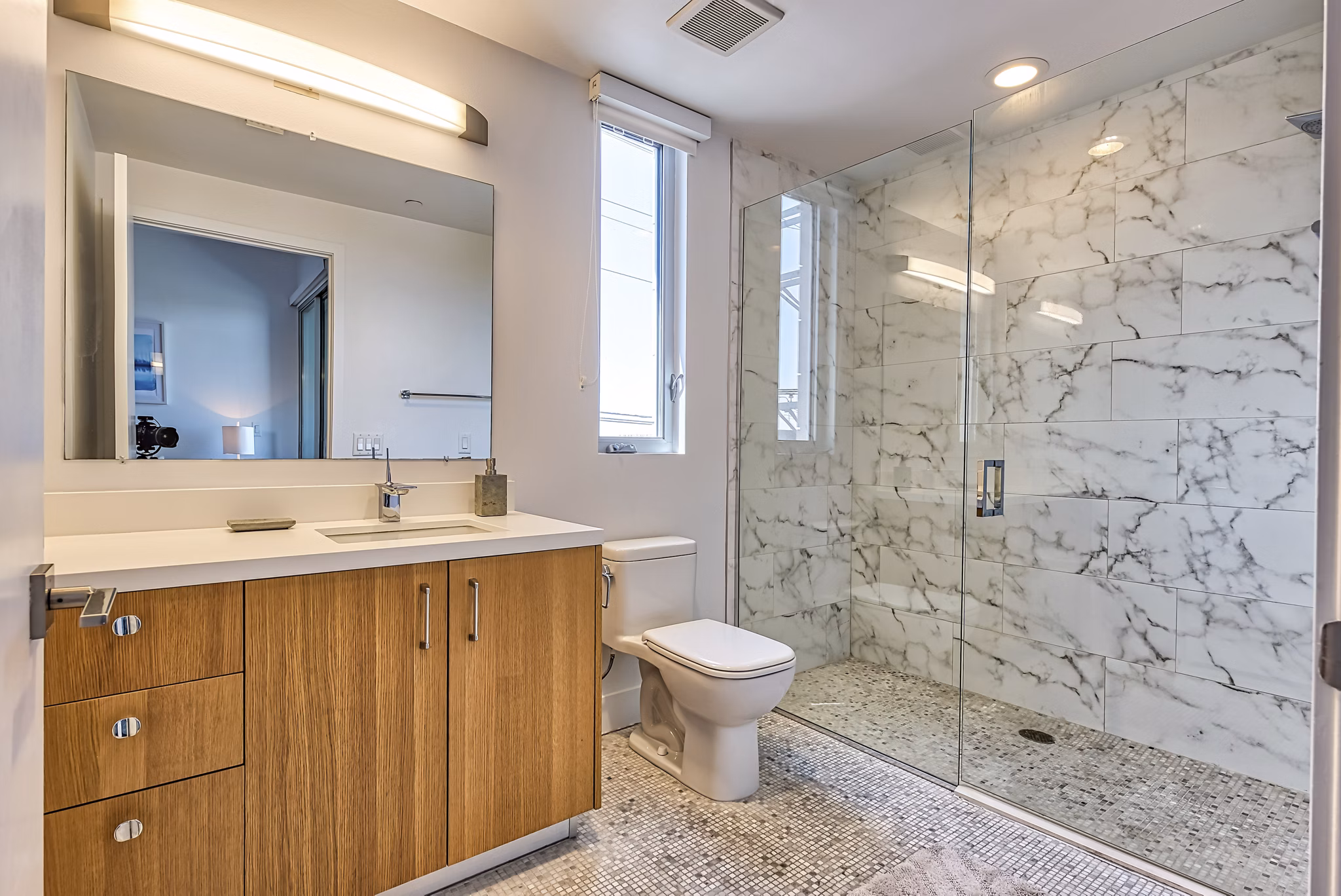 The LC Apartments: Modern bathroom featuring sleek fixtures and marble countertops