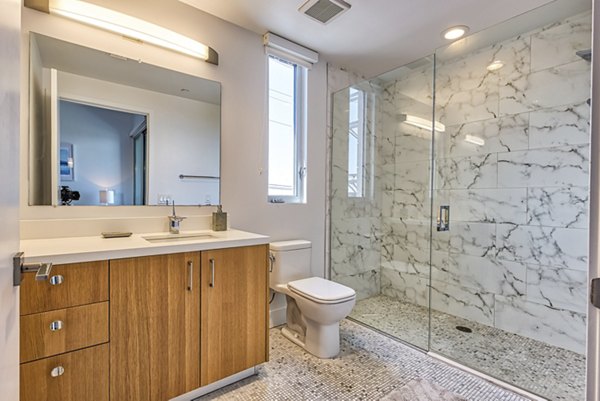 The LC Apartments: Modern bathroom featuring sleek fixtures and marble countertops