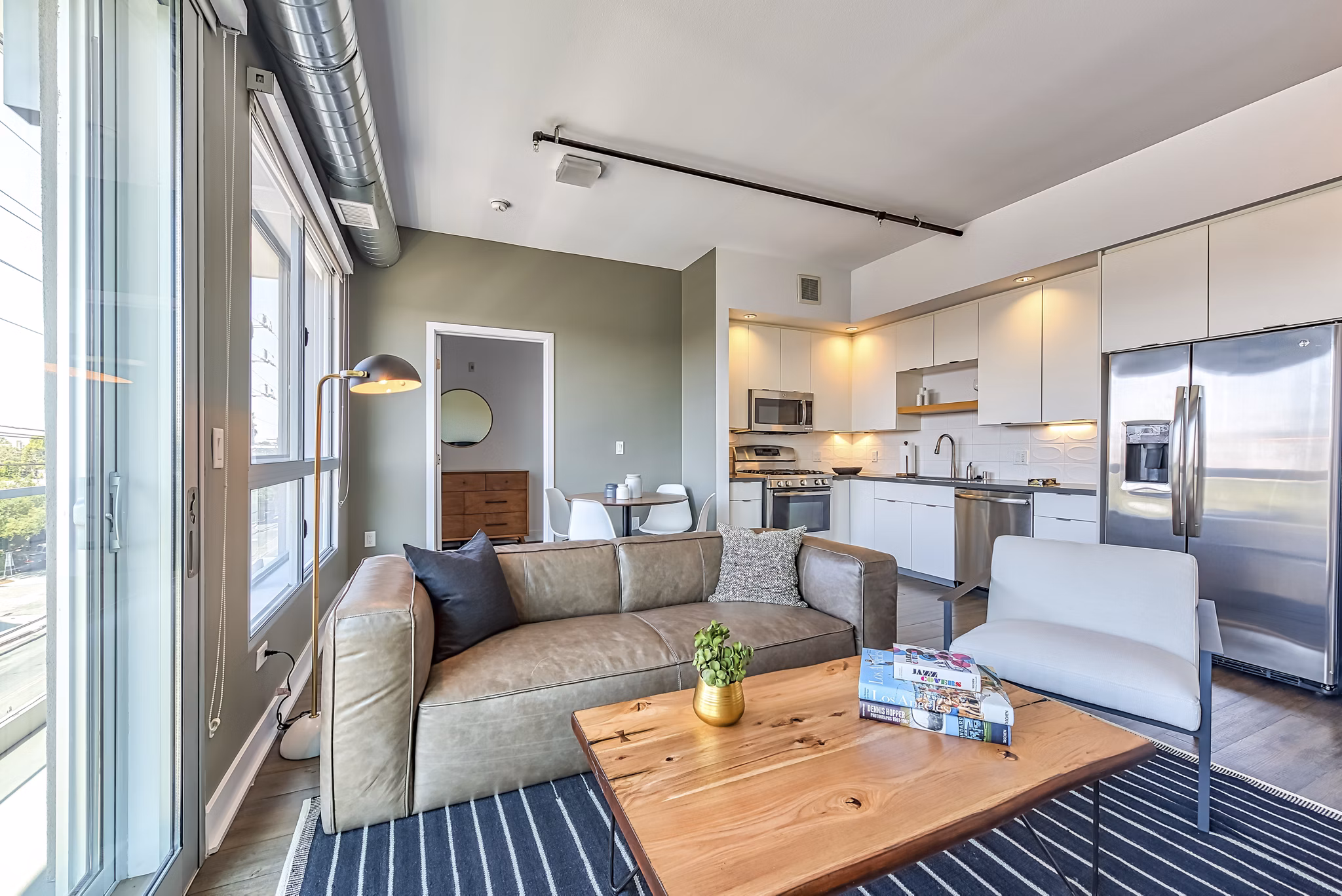 Modern living room with chic furnishings and large windows at The LC Apartments, a luxury residence