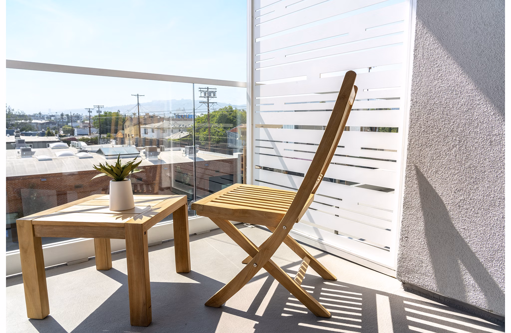Patio with modern seating and lush greenery at The LC Apartments
