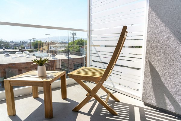 Patio with modern seating and lush greenery at The LC Apartments