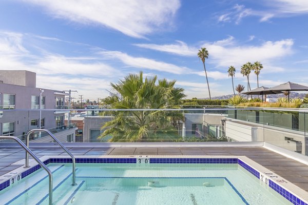 Expansive pool area at The LC Apartments with luxurious lounging options and scenic surroundings
