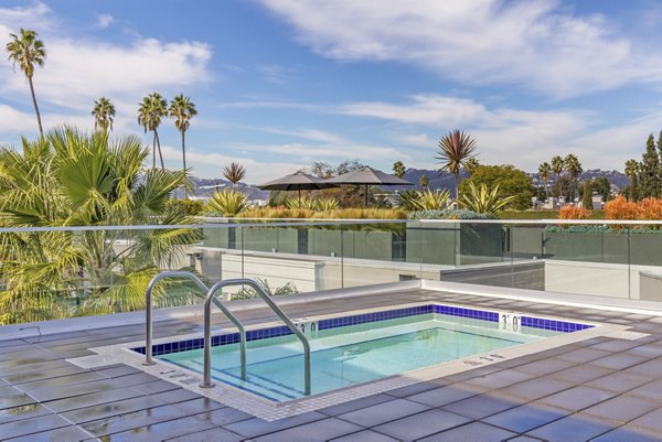 Resort-style pool at The LC Apartments with sundeck and loungers