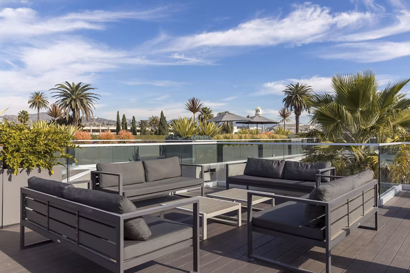 The LC Apartments: Tranquil courtyard with lush greenery and seating areas