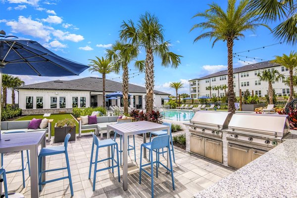 Grill area with modern patio furniture at Ltd Champions Ridge Apartments â€“ perfect for outdoor dining and socializing