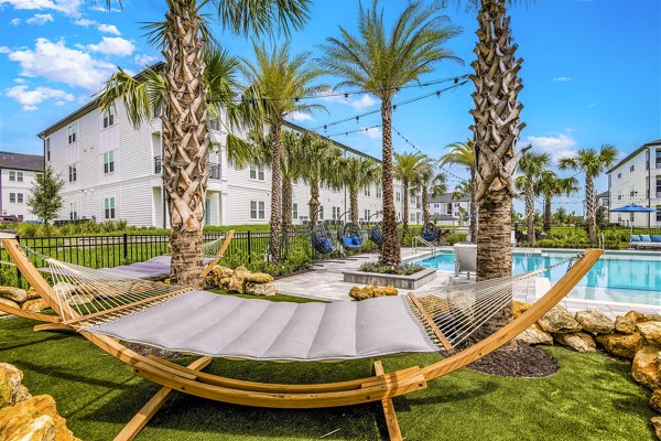 Spacious patio at Ltd Champions Ridge Apartments, featuring modern outdoor seating and lush greenery